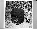 H. E. D. Pollack standing beside Olmec head