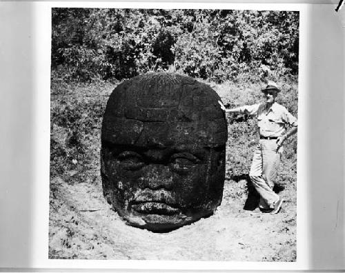 H. E. D. Pollack standing beside Olmec head