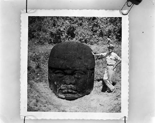 H. E. D. Pollack standing beside Olmec head