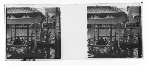 Stereo glass slides of Siam; men and monks soaking in ceremonial bath near dock