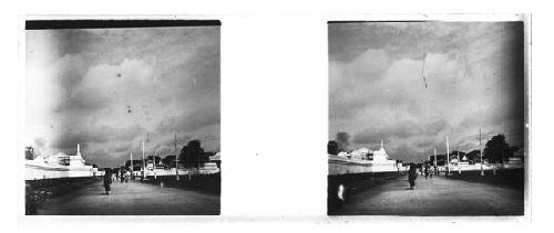 stereo glass slides; people walking on street, wall and buildings on left