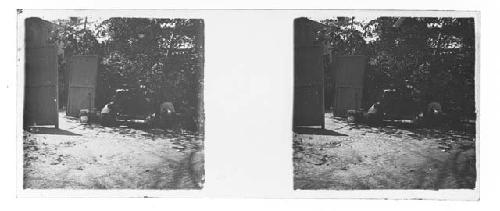 stereo glass slides; person sitting on ground next to makeshift gate