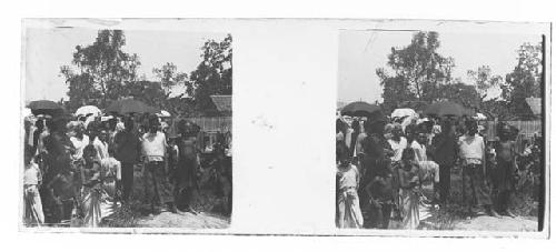 stereo glass slides; villagers holding umbrellas facing camera