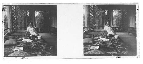 stereo glass slides; blurred view of man seated drinking tea on porch