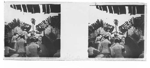 stereo glass slides; men in white uniforms walking on bridge, palm leaves