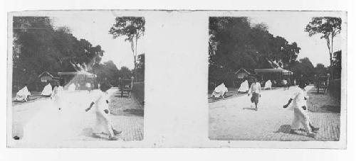 stereo glass slides; people walking on street, covered statues on left?