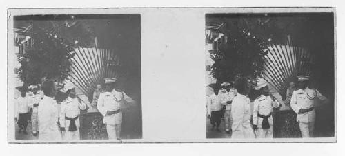 stereo glass slides; men in white uniforms on street, statue in background