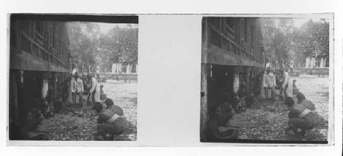 stereo glass slides; seated villagers watching two men with rake or tool