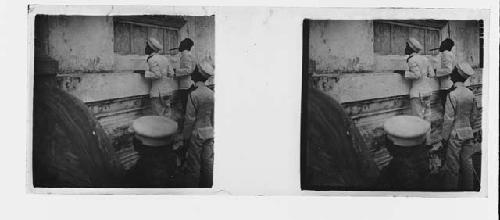 stereo glass slides; men in white hats peering into window