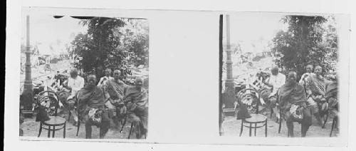 stereo glass slides; buddhists and men in uniform sitting in chairs