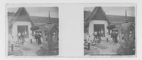 stereo glass slides; military men gathered at entrance of thatched structure