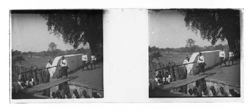 Stereo glass slides of Siam; man crossing makeshift footbridge, others watching