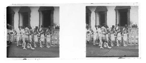 Stereo glass slides of Siam: Men in tradtional garb on walking outside building