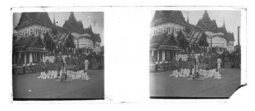 Stereo glass slides of Siam: men and monks seated outside shrine