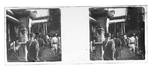 Stereo glass slides of Siam: monks and uniformed men walking on sidewalk