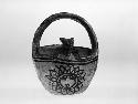 Basket-shaped bowl with handle and animal figure in center