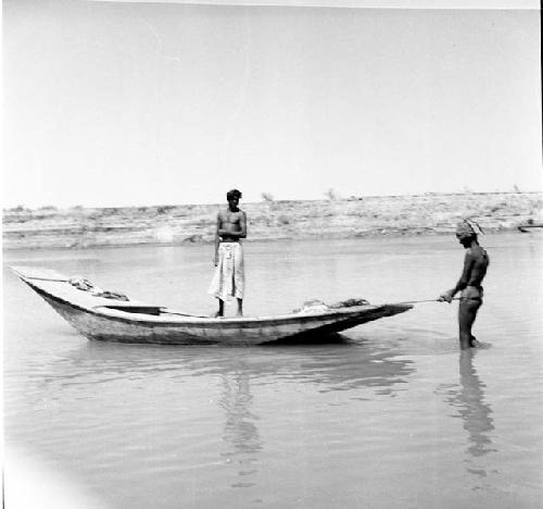 Men stand on and around boat on Indus river at Pattan Ferry