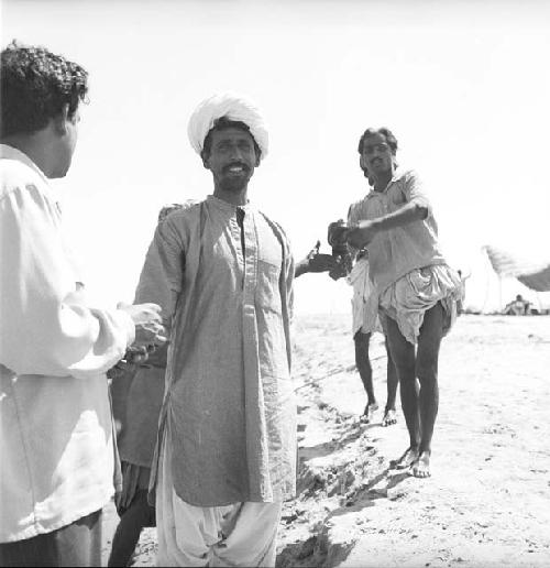 A group of men standing on a beach, Indus river at Pattan Ferry