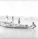 People work around a boat on Indus river at Pattan Ferry