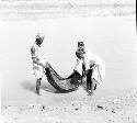 People rinse a blanket out on Indus river at Pattan Ferry