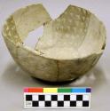 Ceramic vessel, body & rim sherds missing, black on white interior design.