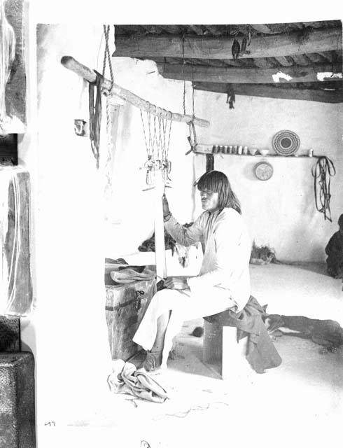 Hopi man weaving a sash on a loom