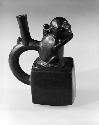 Stirrup pot in shape of a monkey; black cube vessel with handle