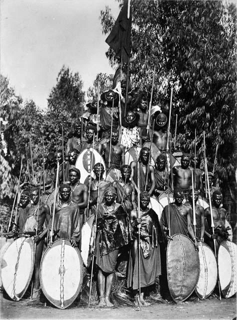 Masai warriors pose in large group with weapons