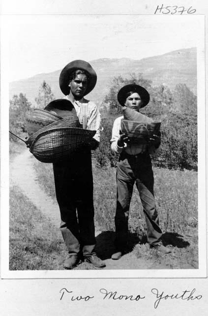 Two boys carrying baskets