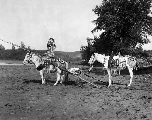 Blackfoot male on horseback with travois