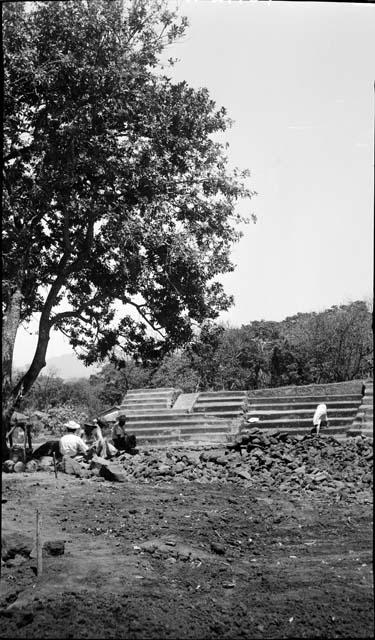 Workers seated around ruins