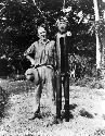 Man standing next to carved figure