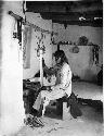 Hopi man weaving a sash on a loom