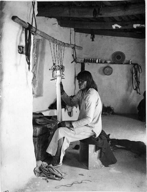 Hopi man weaving a sash on a loom