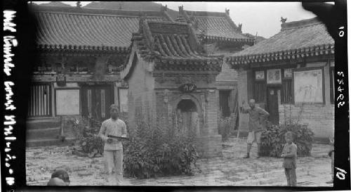 Men and boy standing in courtyard