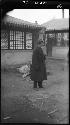 Man in overcoat standing in courtyard