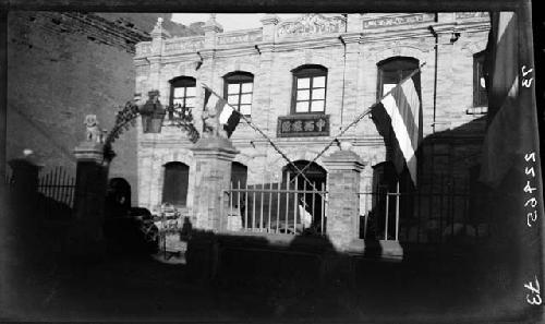 Building with gate and flags in front