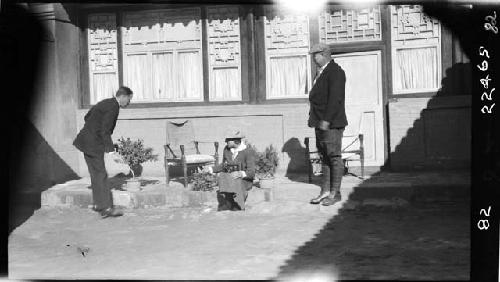 People sit, stand outside home