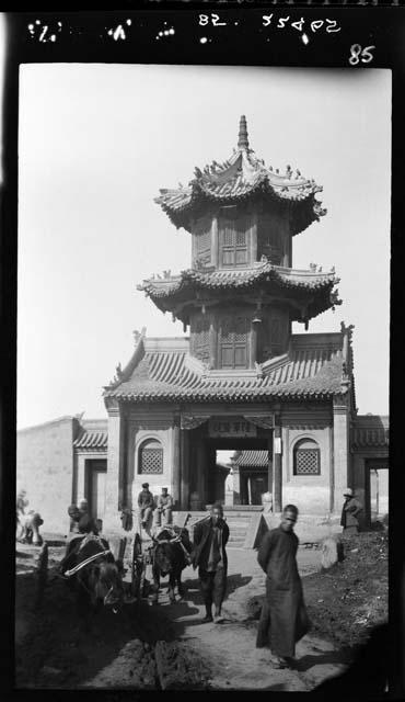 People and animals in front of temple