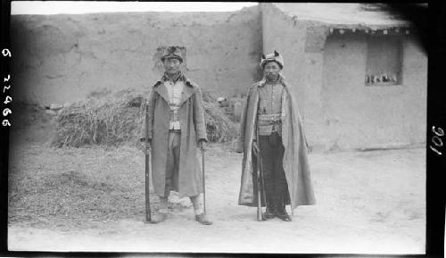 Two men stand outside building