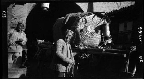 Man stands next to cart loaded with cargo