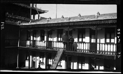 Two people standing on balcony