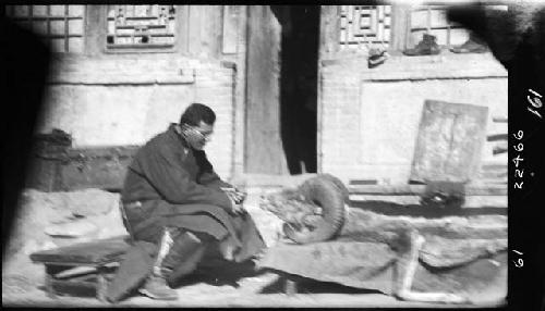 Frederick Wulsin seated next to animal head and skin