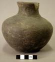 Ceramic complete vessel, short neck, depression in base, chipped rim