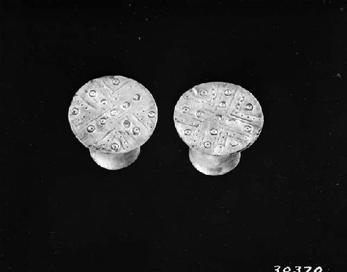 Pair of repousse hollow silver ear plugs, linear design.