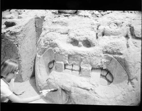 Large clay collossal heads in front of mound with square-crossed fangs and chavin-like features