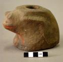 Ground stone frog figurine, red paint on front, holes drilled through top and ba