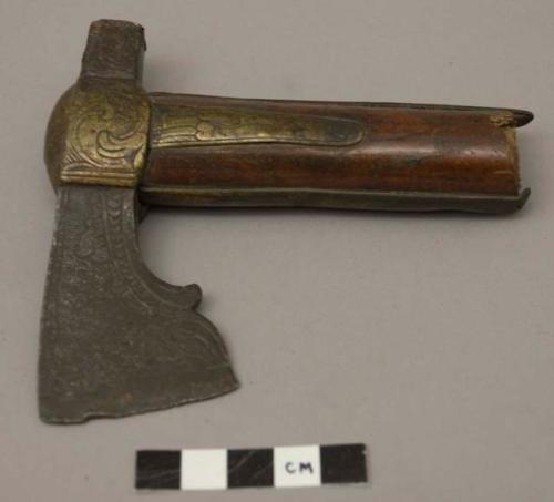 Incised metal axe blade attached to bone handle