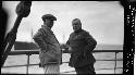 Two men stand on boat