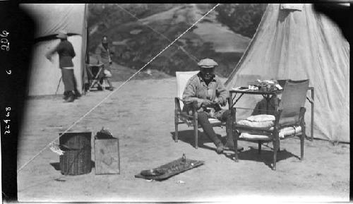 Man sitting in chair outside tent